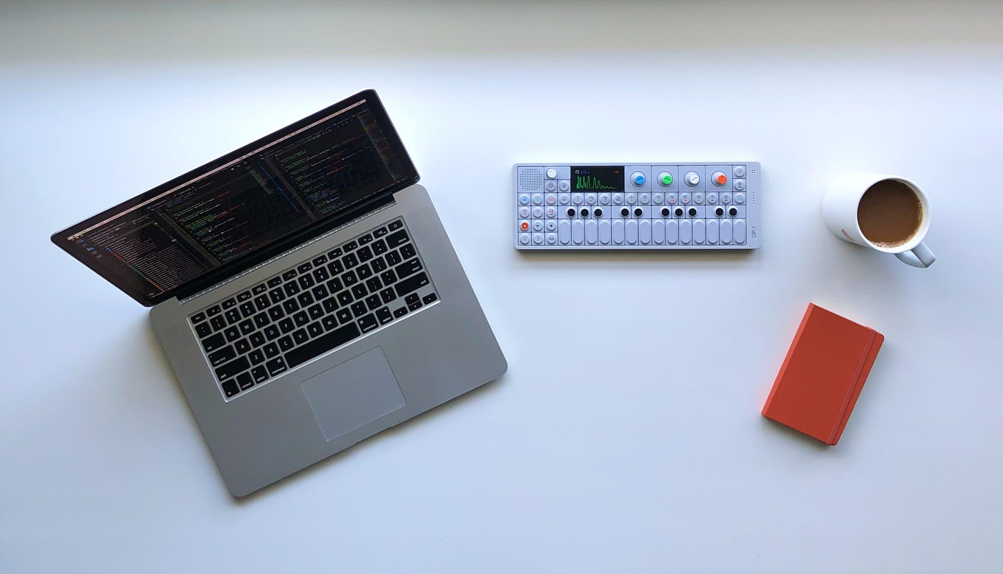 Image of a synthesizer with a laptop and coffee.